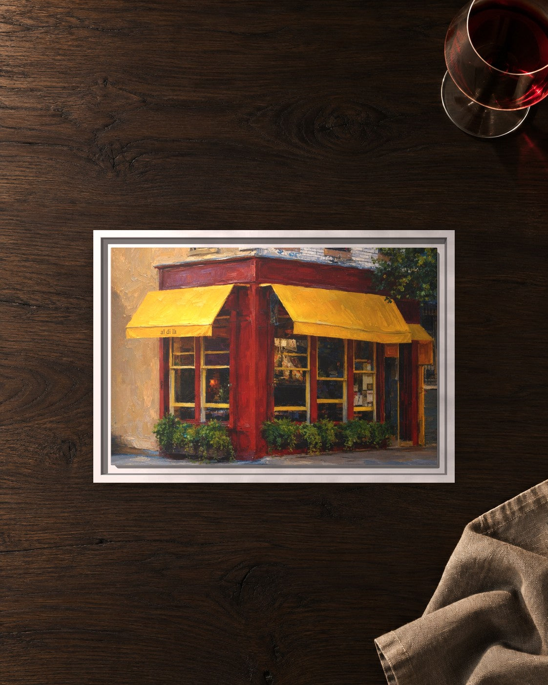 Al Di La Trattoria framed canvas print lying on a table