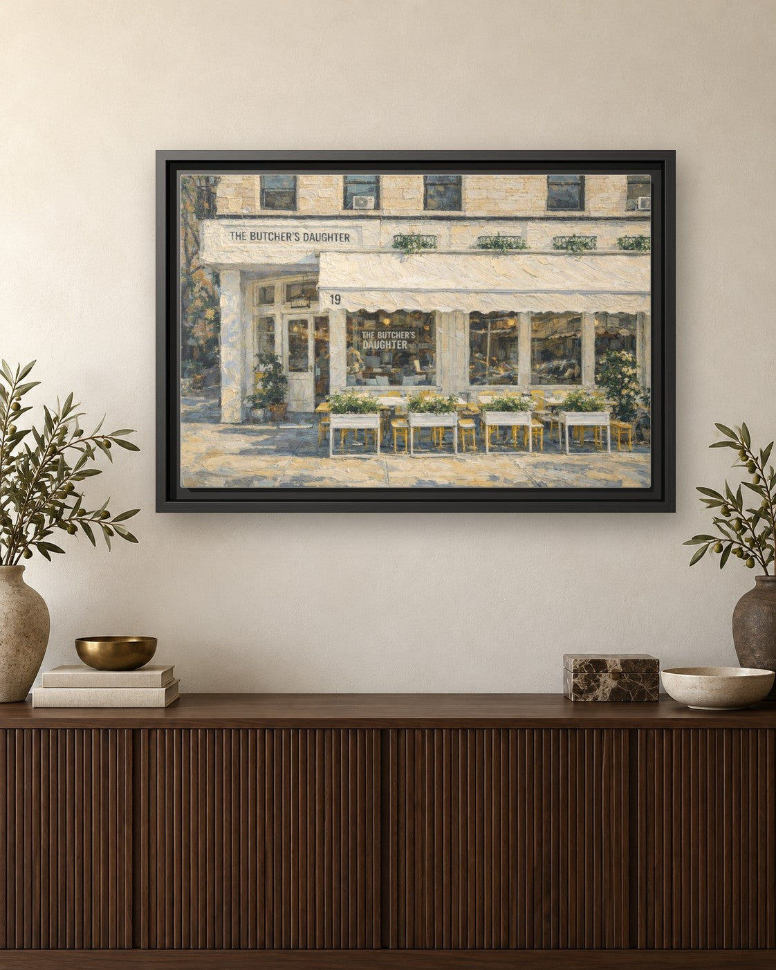 The Butcher's Daughter framed canvas print hanging above a credenza